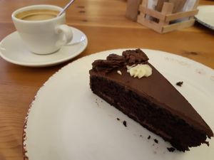 A piece of the three chocolate vegan cake and cortado w/ oat milk at Celicioso Barquillo in Madrid