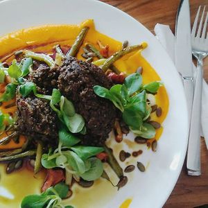Black lentil cutlet chop, great beans, carrot puree, fried pumpkin seeds at Pod Niebieniem in Poznan