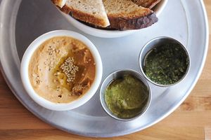 Dip Flight: three delicious housemade dips (all vegan!) served with homemade sourdough, cucumbers, or both! at Savage Goods in El Paso