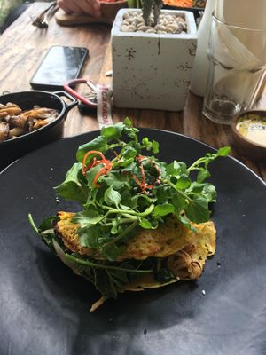 The vegan chickpea omelette: served with coconut cheese, fried spinach,  potatoes (inside omelette) and greens.  at Two Trees Eatery in Tibubeneng