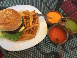 Lentil burger with vegan mayo, side sauces and homemade fries at Jardin La Reserva Restaurante in San Cristobal De Las Casas
