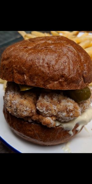 White residue on "Nashville hot 'chicken' burger patty, with a thin thread underneath at The Blacksmith & The Toffeemaker in London