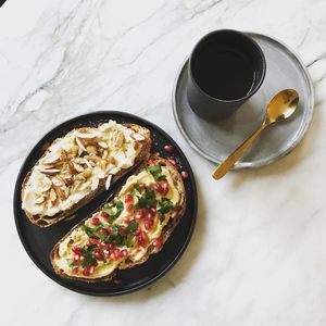 A Zaczyn breakfast: batch brew coffee, toast with white beans spread, almonds and rosemary olive oil, toast with hummus, pomegranate, parsley and olive oil. Photo by Magda Łapińska at Zaczyn in Krakow