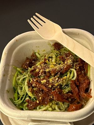 Side dish, courgette spirals in pesto, with sun-dried tomatoes, served cold. at Purezza Camden in London