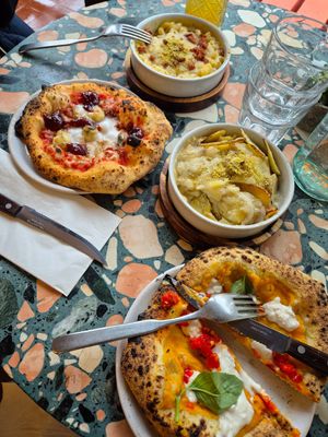 Mac and cheese, Four Cheese Pizza, roast potatoes, and Fuoco d’Amore Pizza. at Purezza Camden in London