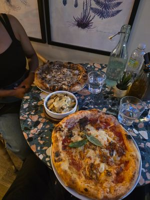 Parmigiana party nearside and I think black truffle pizza on far side my wife ordered. Garlic potatoes in the middle. at Purezza Camden in London