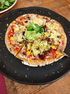 Pizza con guacamole, piña, queso vegano, tomate seco, maíz y champiñón at Beet Vegetariano in Torrevieja