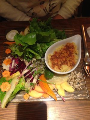 Dish of raw fruits and vegetables with spelt grains and seeds at Toutes Les Couleurs in Lyon