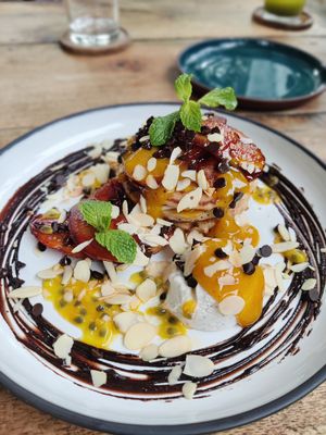 Loaded pancakes with Caramelised bananas, Fresh passion fruit and banana, Chocolate ganache, Mango coulis, Flaked almonds, Coconut cream at Nomad Café | Boutique in Weligama