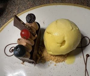 This is half the chocolate mousse cake. My husband had the other half and they pre divided it. Served here with mango gelato.   at Ike's Bistro in Oranjestad