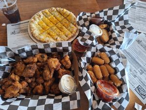 Top left corner going clockwise, cheesy bread. Chicken tenders mozzarella sticks ,cauliflower wings with vegan ranch at Chattanooga Pizza Co in Chattanooga