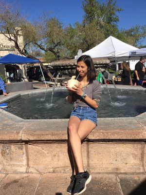 Sipping on a young Thai coconut at the center of the food stands.  at St. Philip's Plaza Farmers' Market in Tucson