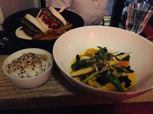 Left: 2 different vegan bao burgers with sweet potato fries; right: tom yum with tofu, vegetables and rice at Marclee in Paris