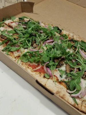Multigrain dough with mushrooms, red onion, spinach, arugula, and vegan cheese at Zablong in Cincinnati