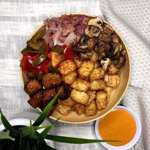 Philly Cheesesteak Bowl:
Crispy baked tater tots topped with a rich beefy tempeh, soaked with au jus gravy, sautéed peppers, onions, mushrooms, and drizzled with warm house chees at Chip and Kale in Pittsburgh