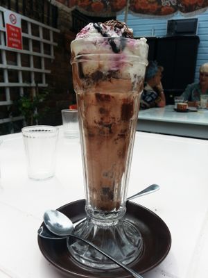 Vegan knickerbockerglory with raspberry ripple, fudge and chocolate icecreams, and vegan chocolate brownie pieces inside at Revival in Whitstable