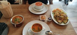 Vegetarian paneer tikka (right), vegan tofu with peas and tomato sauce (left) and two soups - vegetarian & vegan at Bhajan Cafe in Krakow