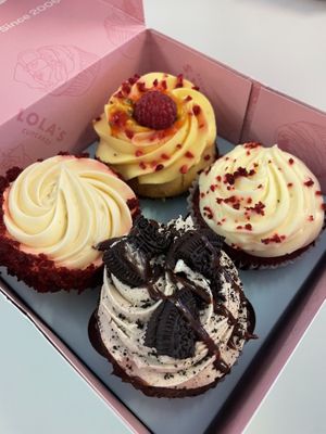 Top and the cupcake at the 9 o’clock position are vegan. Passionfruit and red velvet    at Lola's Cupcakes - Victoria Place in London