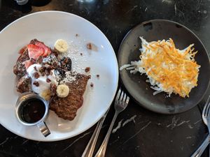 Banana bread french toast with a side of hashbrowns at Saddle Creek Breakfast Club in Omaha