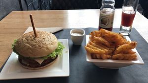 Sesame bun, lentil patty, organic mayonnaise, roasted peanuts and popped carrots. Apple and Cherry juice. Side is potato wafers.  at H&K's - Vlaamsesteenweg in Brussels