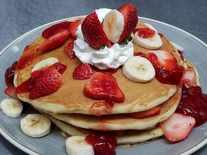Vegan pancakes with strawberries topped with strawberry compote and coconut whipped topping. at Gloria's Restaurant in Sudbury