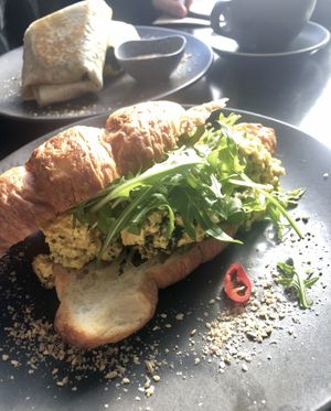 Green ‘Eggs’ (tofu scramble with pesto & spinach, topped with rocket, dukkah & chilli on a croissant) at Dicki's in New Farm