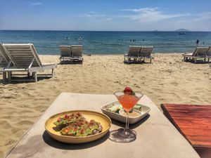 Food brought to us on the beach - Simmer Time cocktail, avocado toast and spring roll at The Fisherman Vegan Restaurant   in Hoi An