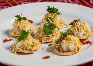 Puri is comprised of crisp homemade wafers topped with onions, potatoes, assortments of chutneys, chickpea crisp noodles, and garnished with cilantro. Can be made vegan. at All India Cafe in Glendale