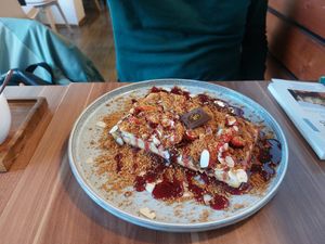 Vegan waffle with strawberry, chocolate spread, lotus cookie crumble, almonds, and disgusting blueberry syrup at Cafe Waffle in Prague