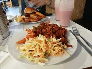 Jackfruit with coleslaw and sweet potato fries. Burger in background at The Vegan Grill in Croydon
