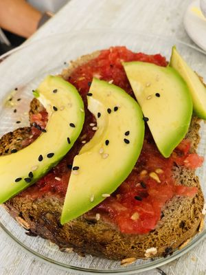 Tostada de pan multicereal y semillas con tomate y aguacate at Dulces Dreams in Malaga