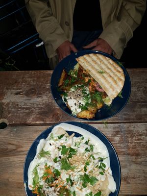 Above the pita with seitan, baked potatoes with garlic sauce and fresh herbs. Underneath dumplings in sour cream. at Kuschlowski in Berlin