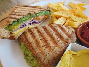 Vegan sandwich with vegan cheese, tempeh. Chips on the side at Bar Ecologico Gaia in Sevilla