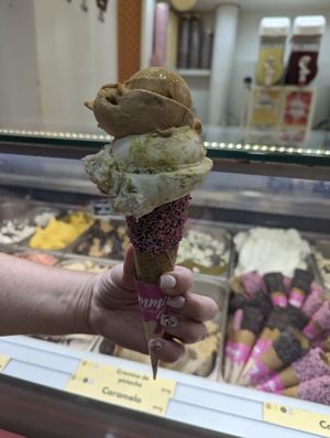 Medium waffle cone with pink sprinkles, pistachio (bottom) and caramel (top) at Yummy Helados in Malaga