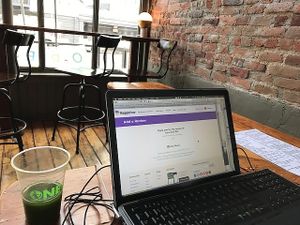 My green juice is in the biodegradable cup to the left and this is one side of the inside seating with more seating outside. at Superfood Bar in Denver