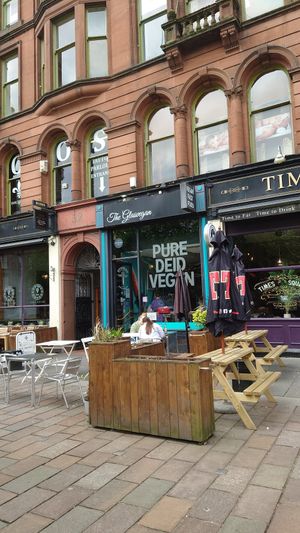Facade with outdoor seating at The Glasvegan in Glasgow