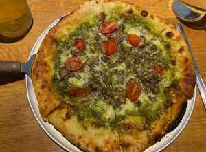 Pizza with vegan cheese, pesto and tomato at Harvest Pizzeria in Dublin