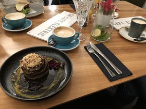 Matcha Pancakes with oat milk cappucino (breakfast burger in the background) at Cafe Elektric in Prague