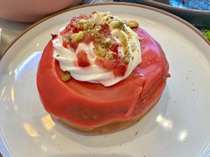 Strawberry fields donut (Strawberry glaze, pistachio praline and whipped cream topped with fresh strawberries & almond streusel)  at L'Artisane Creative Bakery in Coral Gables