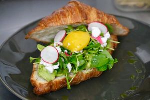 Avocado toast - avocado purée, vegan cheese crumbles, watercress, poached vegan egg, radish at L'Artisane Creative Bakery in Coral Gables