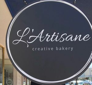 The sign outside at L'Artisane Creative Bakery in Coral Gables