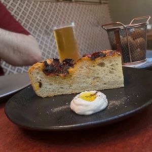 Focaccia with a “whipped tofu”. This felt underbaked on top and the whip was runny with no real flavor.  at Alibi in Sydney