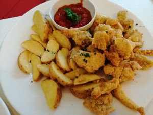 Fried seitan in cornjackets with steak potatoes and spicy sauce at Veganeria in Budapest
