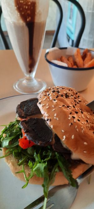 Choc shake, portobello shroom in a bun with rocket, tomatoes, onion roasted peppers. Basil pesto and aioli sauce. at Soul Burger in Newtown