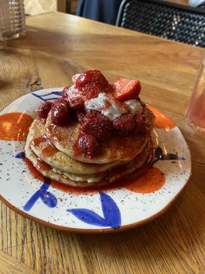Strawberry pancakes (almond flakes were erronously delivered later): quite good, but too sweet. Also, the chocolate sprinkles were tiny flakes on the edge of the plate. at Karibu Cafe in Utrecht