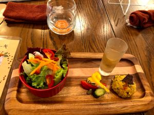 appetizer salad with pickled veggies, some paste and a shot of sweet juice to balance the sour salad dressing. very good! at Premarché Alternative Diner in Kyoto