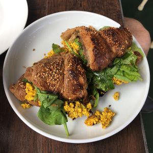 Multigrain croissant (turmeric tofu scramble, spinach, avocado, arugula salad) at Fermento in Long Beach