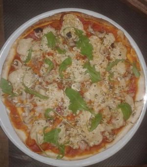 Pizza Farfalla vegano casera con salsa de tomate, champiñones, cebollas, pipas, hummus y rucula. at La Taberna Farfalla in Carboneras