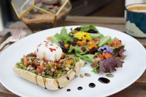Avocado toast with an organic poached egg, tomato salsa, balsamic reduction, served on locally made ciabatta bread with a side house salad. at GreenHut - Food Truck in Squamish