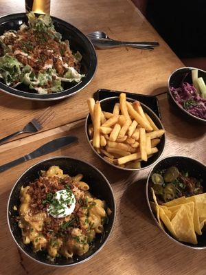 Caesar salad, mac n cheese, chips, chili bowl, slaw at Rudy's Dirty Vegan Diner in North West London